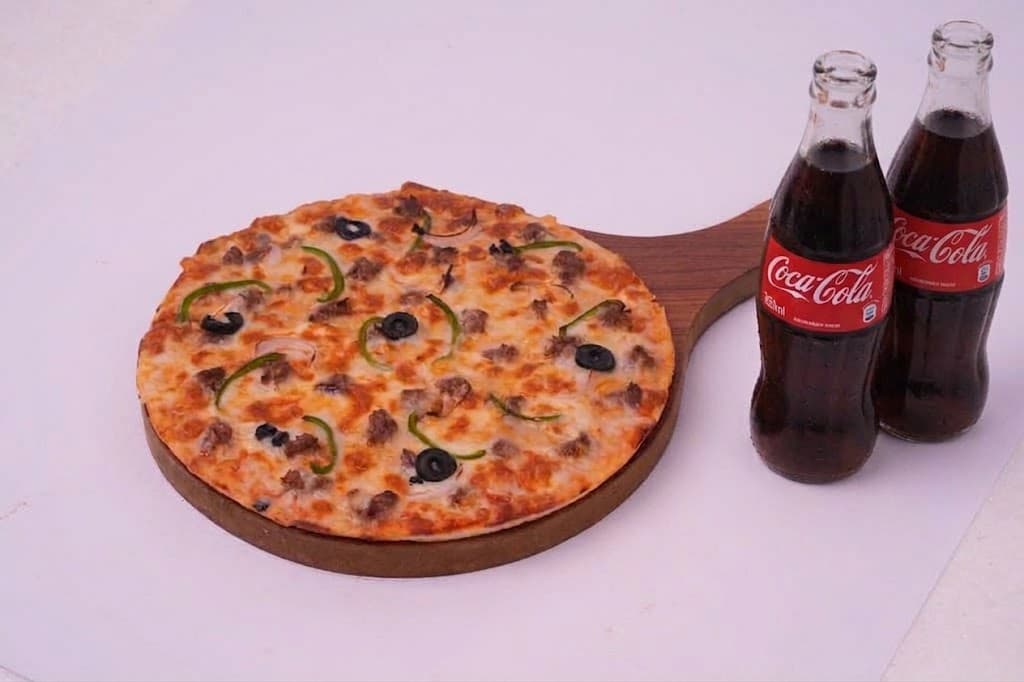 A medium pizza with two bottled drinks
