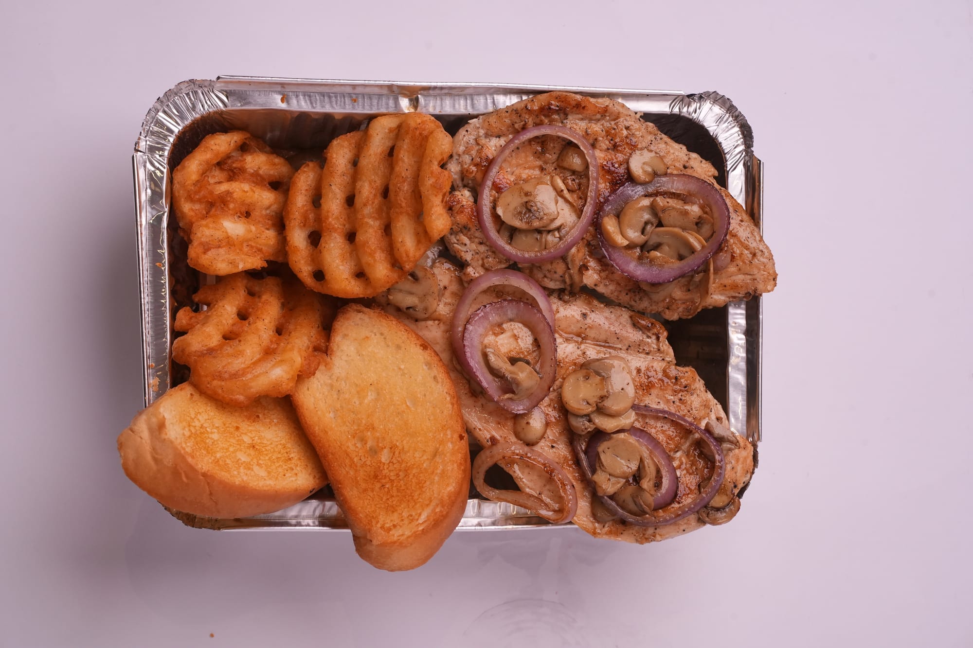 Grilled chicken with waffle fries and garlic bread